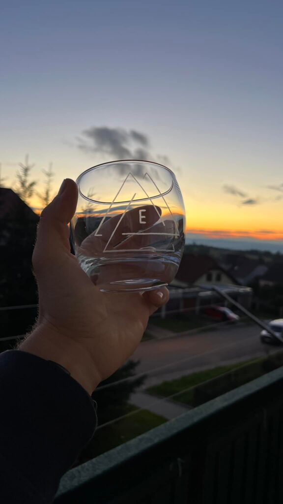 a hand holding a glass with a triangle design