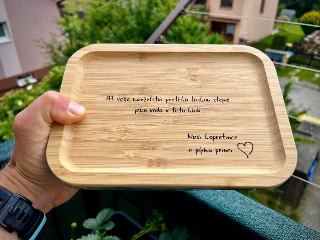 a hand holding a wooden tray