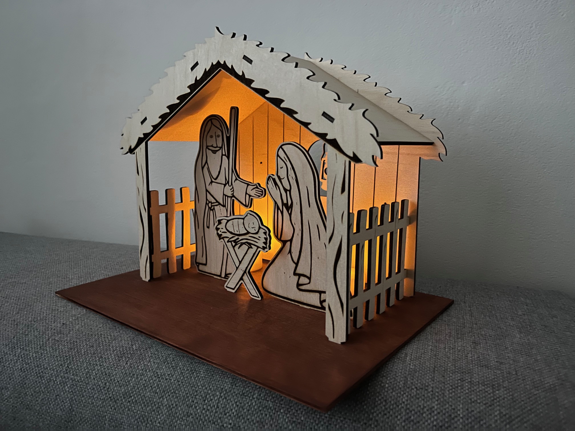 a wooden nativity scene with a lit up window